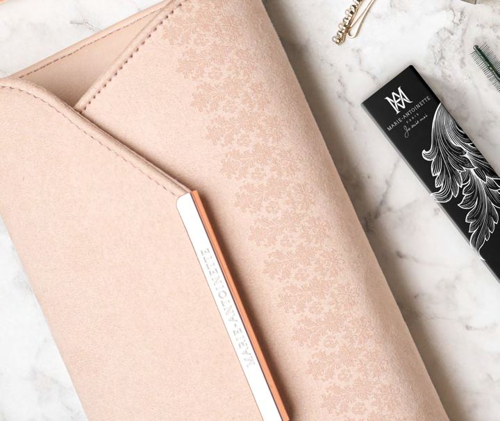 A blush-pink Marie-Antoinette clutch with an embossed pattern
