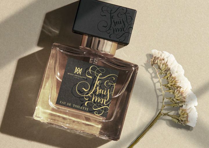 A Marie-Antoinette perfume bottle beside a sprig of dried flowers